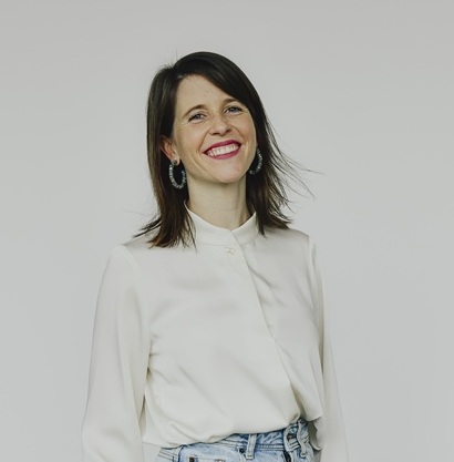 © Matthias Jacoby A young woman in a white blouse and jeans is smiling into the camera.