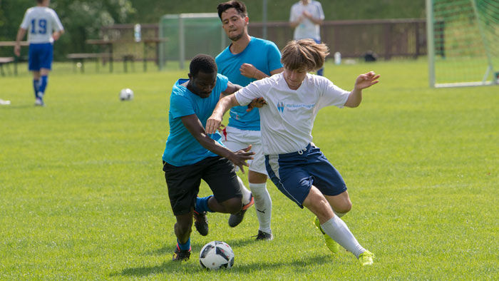 Two footballers battle for possession of the ball.