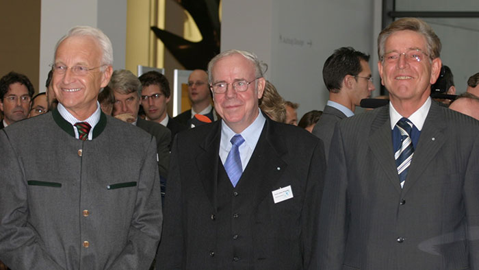 Group photo: three smiling men face the camera.