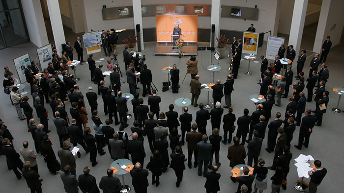 Group photo: a large audience listens to a speech.