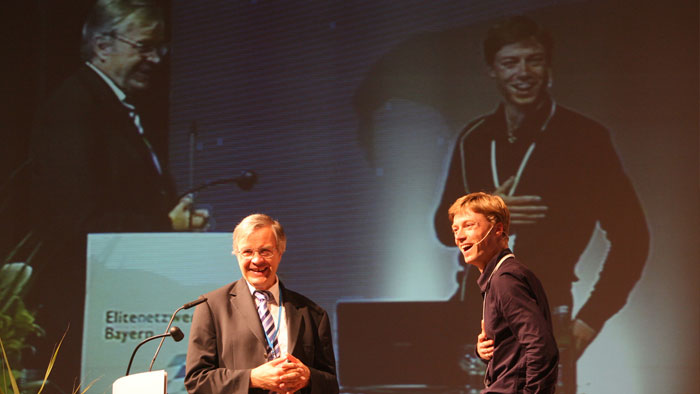 Following a speech, a moderator converses with a speaker.