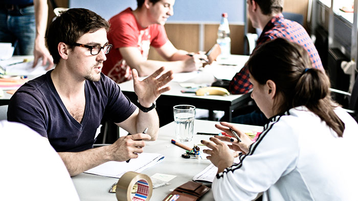 Two young people engage in an animated dischussion in the course of a lesson in a conference room