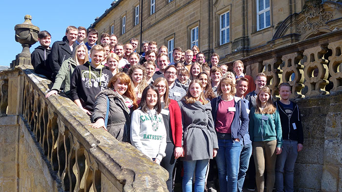 Alt-Text The participants of the 2018 spring school standing on a staircase in front of Kloster Banz.