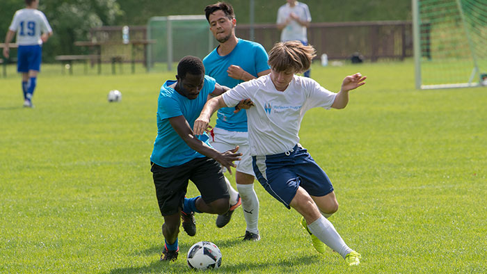 Zwei Fußballer liefern sich einen Zweikampf um einen Ball.