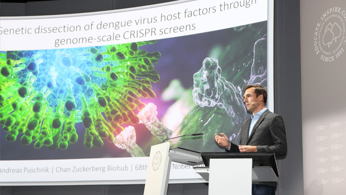 Ein junger Mann hält einen Vortrag über seinen Forschungsansatz zu viralen Infektionen. 