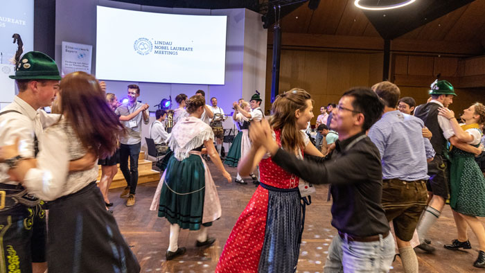 Young people from different countries dance to brass music in their national dress.
