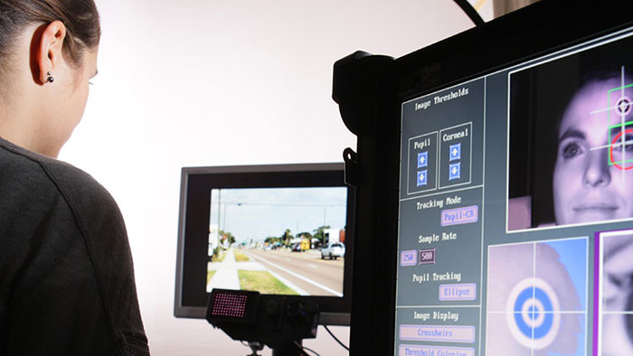 Picture of a person controlling the measurement of eye movements of a study participant on a monitor. 