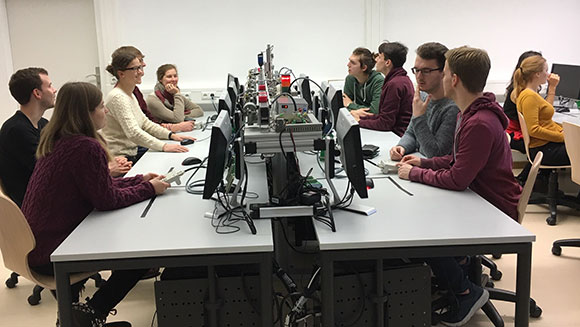 Studierende arbeiten gemeinsam in einer Laborumgebung an Computern.
