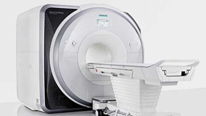 Close-up picture of an MRI scanner with tube and scanner couch. 