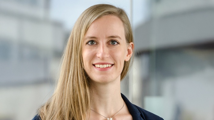 A young woman with long blonde hair is smiling at the camera.