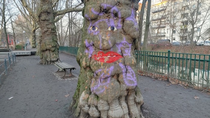 A tree that has a face painted on it.