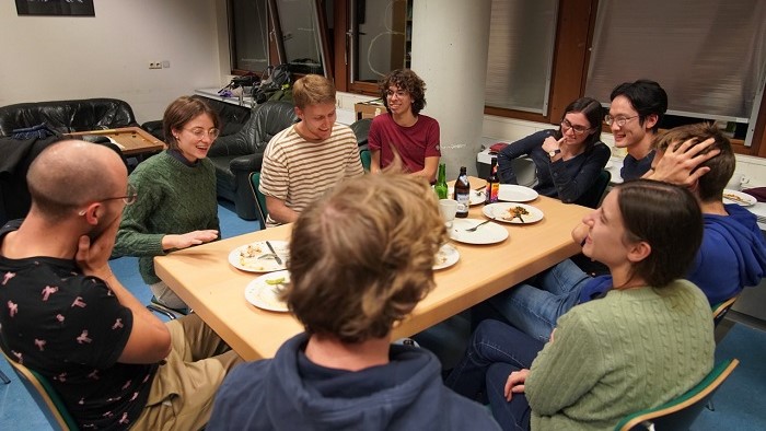 Students have gathered around a dinner table.