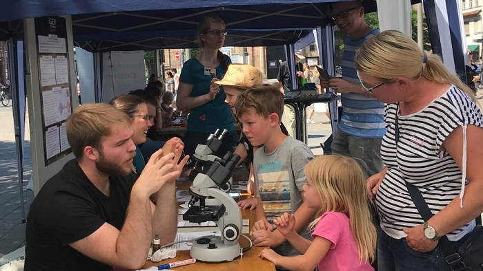 © Dr. Agnes Giniewski Students of the Master's programme Integrated Immunology explaining pathogens under the microscope as part of public relations work.