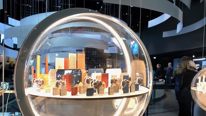In einer Glaskugel wird ein Modell für die Stadt der Zukunft gezeigt.