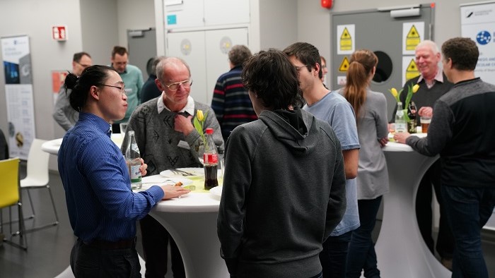 A group of younger people talks to an older man.