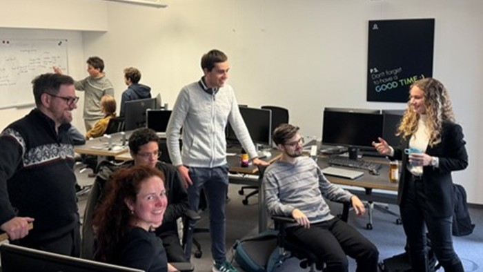 © Elitestudiengang „Software Engineering“ Eine Gruppe Menschen diskutiert in einem Besprechungsraum.