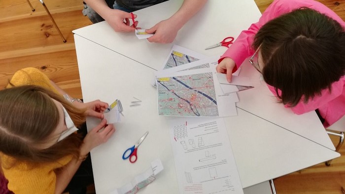 Three students are studying Miura folding - a technique borrowed from nature that is used, among other things, to fold city maps.