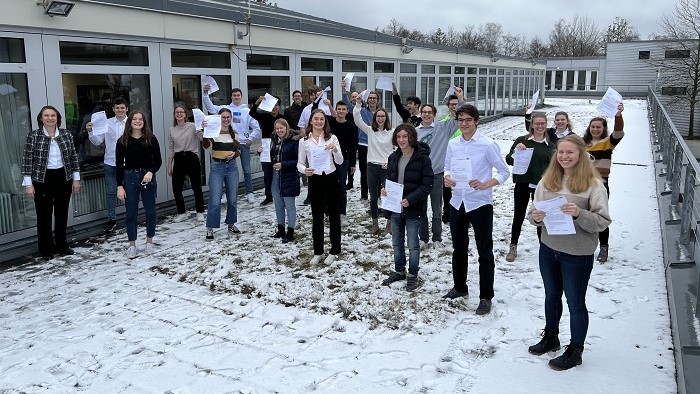 Eine Gruppe von Menschen auf einem Dach, die Urkunden in der Hand halten.