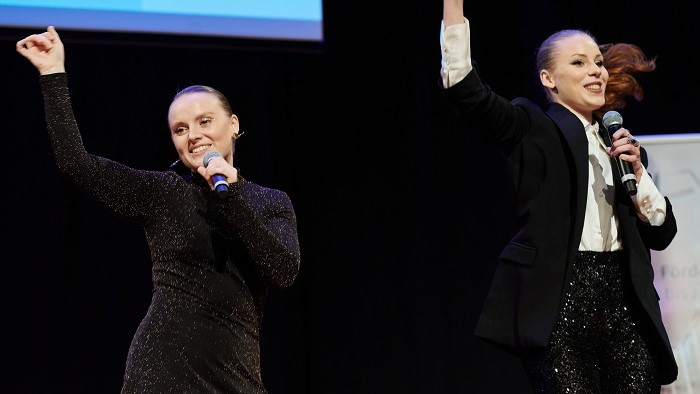 Two female singers performing on stage