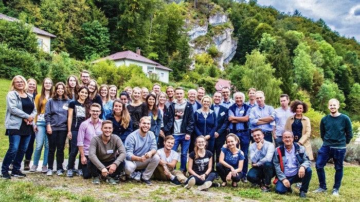 Group photo of the participants of the retreat in front of a rocky landscape in Franconian Switzerland