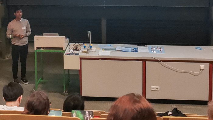Ein junger Mann spricht in einem Hörsaal zum Publikum.