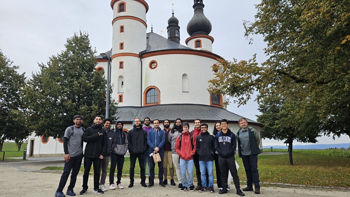 The participants of the Modelling Seminar 2025 gathered for a group photo. In the background, an architecturally remarkable church can be seen, considered a landmark of the region.