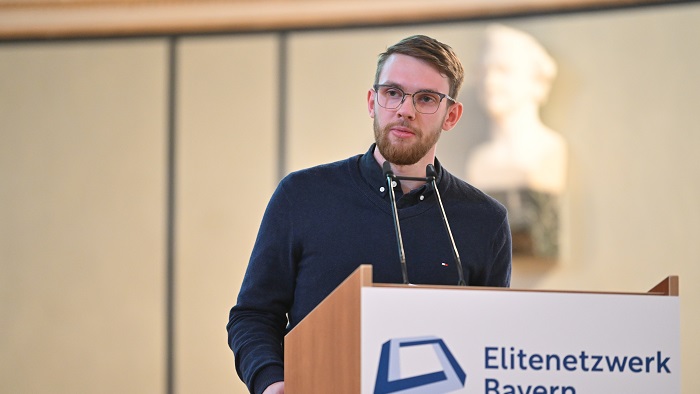 A man behind a lectern talking to the guests