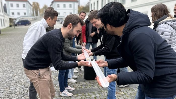 Young people take part in a team-building game in a castle courtyard.