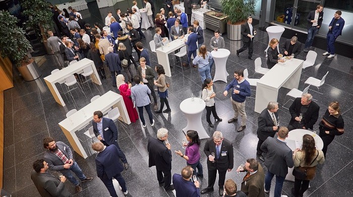 Menschen essen an Tischen in einem großen Foyer