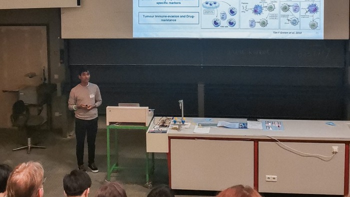 An iImmune student gives a lecture on immunotherapy in the main lecture hall