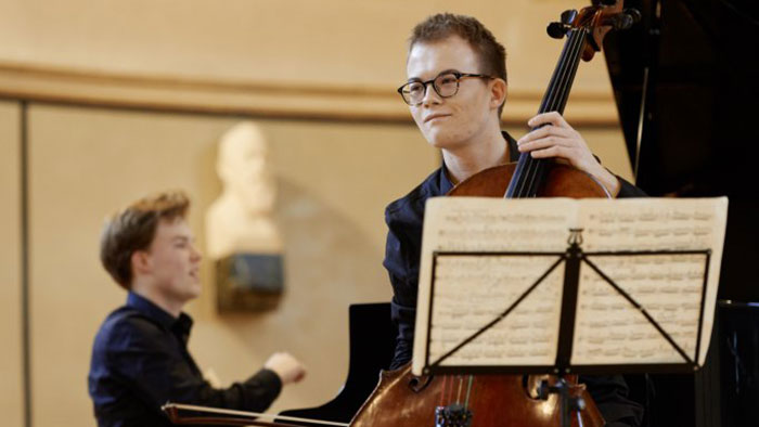 A cellist and a pianist play a piece of music together.