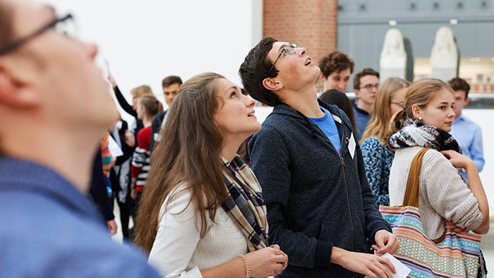 Three people in the foreground looking upwards in amazement.