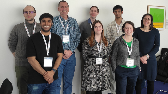 A group of young people in front of a wall.