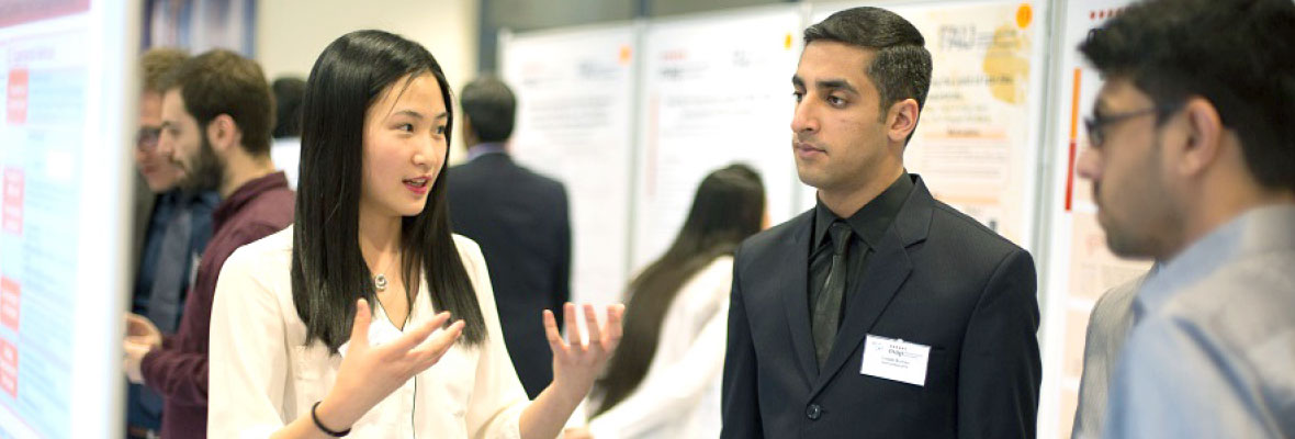 Photo of an event: three young people are engaged in conversation.