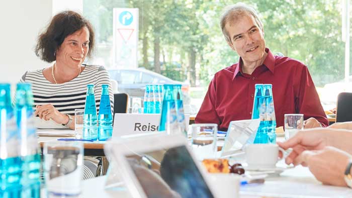 Ein Mann und eine Frau hören einer nicht im Bild befindlichen Person aufmerksam und wohlwollend zu.