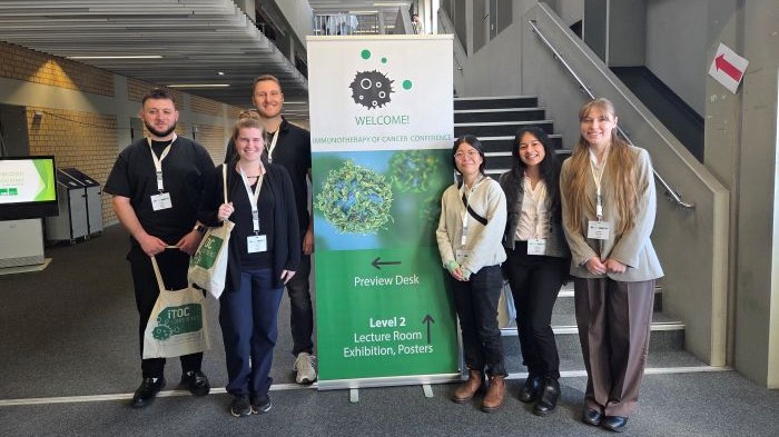 Gruppenfoto von sechs Studierenden der 7. Kohorte des Masterprogramms Integrated Immunology auf der „ImmunoTherapy of Cancer“ Konferenz 2026.
